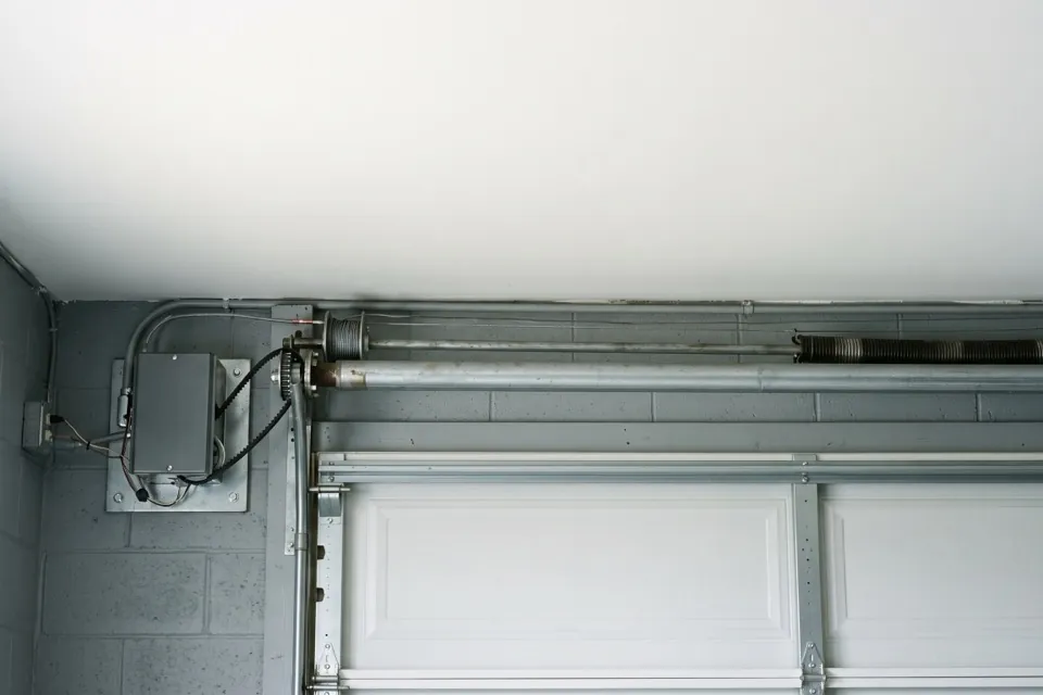 A wall-mounted jackshaft garage door opener fitted beside the torsion shaft